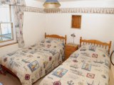 The Twin Bedroom at Lighthouse View overlooks the courtyard and the Lighthouse.